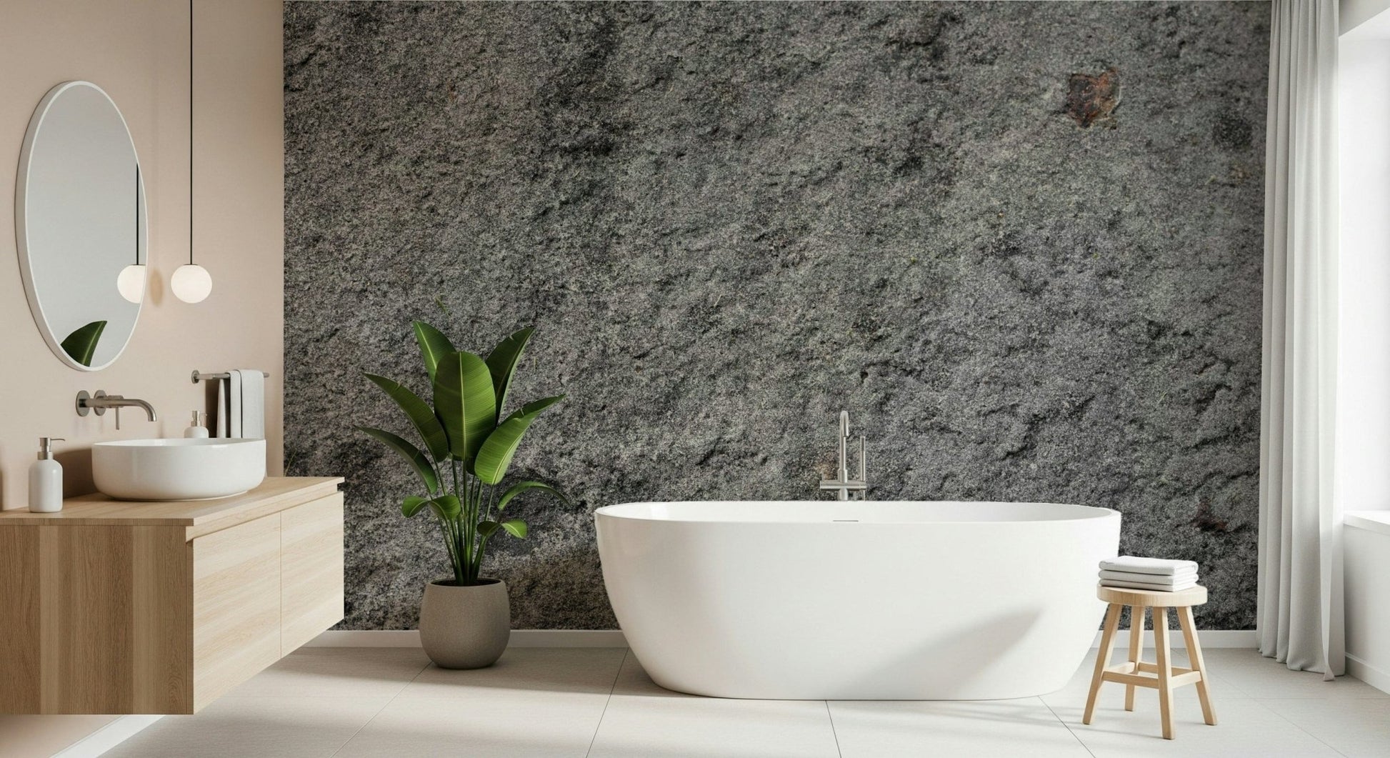 Granite Gray wallpaper mural behind a white freestanding tub, wood vanity and banana-leaf plant in a bathroom