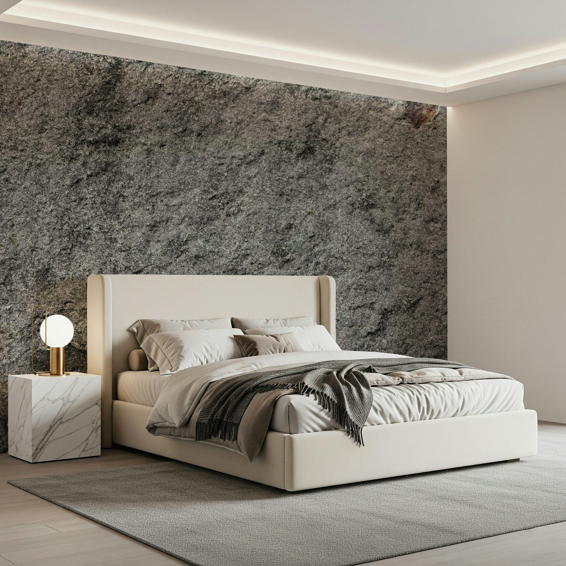Granite Gray wallpaper mural above a cream upholstered bed with a marble cube nightstand and grey throw