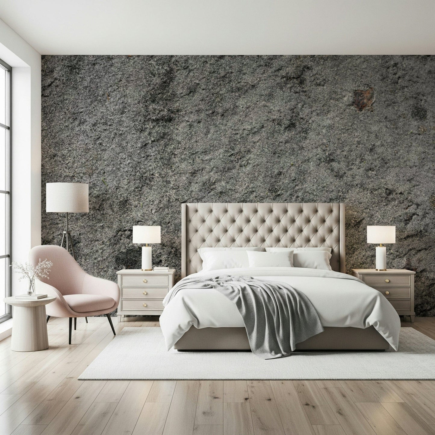 Granite Gray wallpaper mural above a cream tufted bed with a pink accent chair and twin lamps