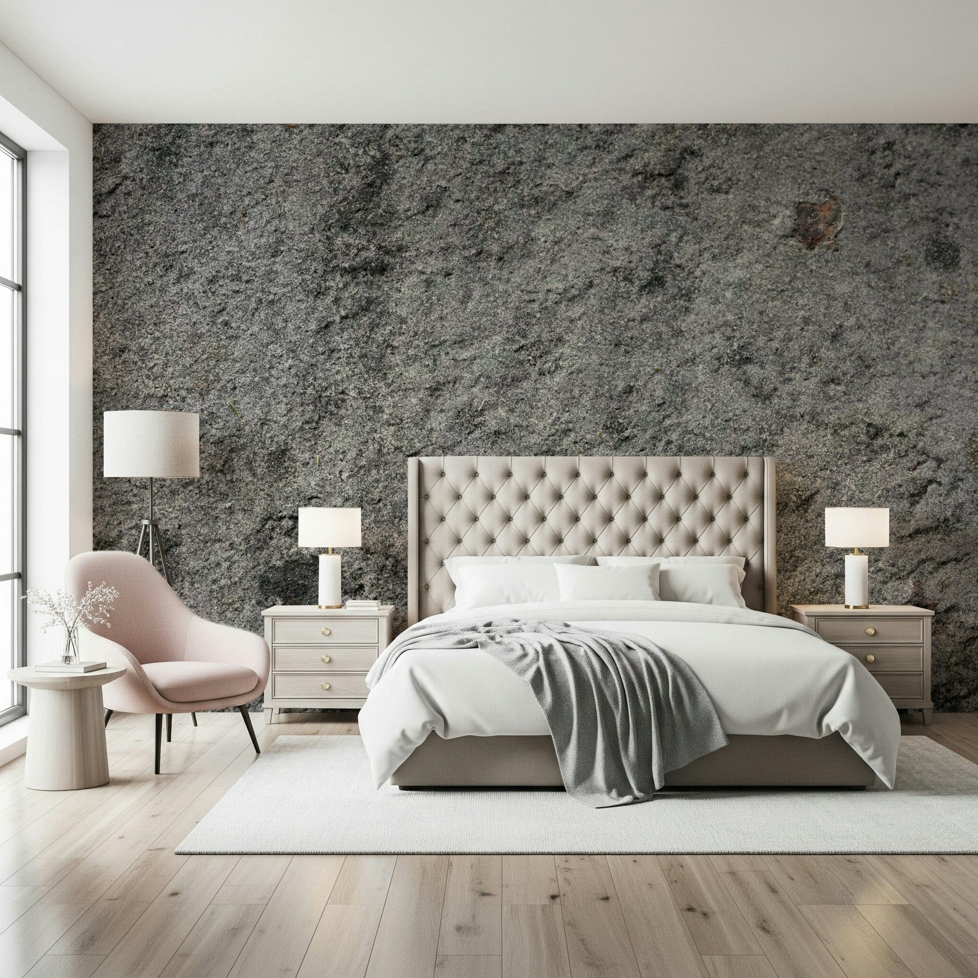 Granite Gray wallpaper mural above a cream tufted bed with a pink accent chair and twin lamps