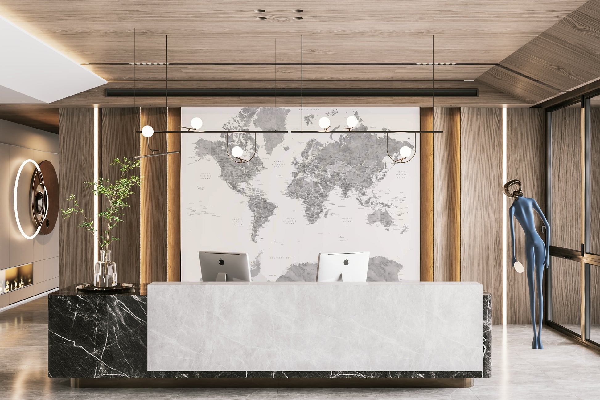 Gray Watercolor World Map wallpaper mural in soft gray behind a marble reception desk with two iMacs