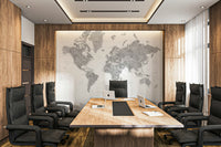 Gray Watercolor World Map wallpaper mural in soft gray behind a long wood table in a boardroom