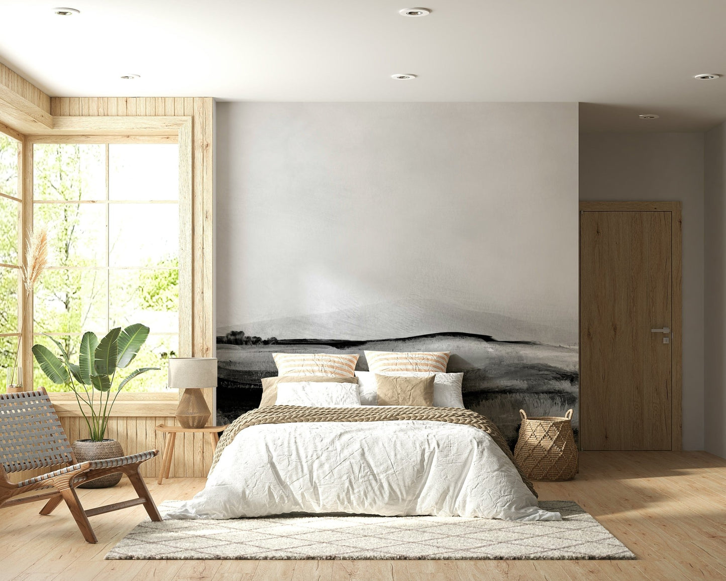 Grayscale Hills wallpaper mural in a boho bedroom with a white-bedded bed, woven leather chair and leafy plant