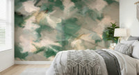Ethereal Brushstrokes wallpaper mural in green and cream behind a bed with a macrame throw and bedside plant