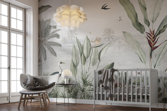 Green Forest Birds wallpaper mural with palms and a crane behind a grey crib and rattan chair in a nursery