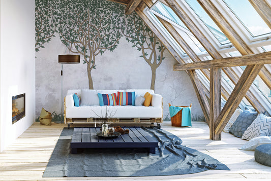 Green Painted Trees Concrete wallpaper mural of leafy trees behind a white pallet sofa in a sunny attic loft