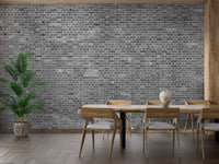 Grey brick mural behind a wooden dining table setup