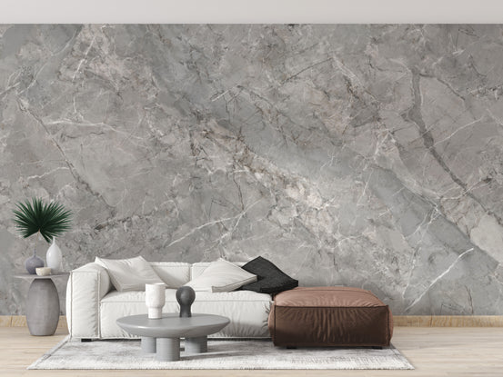Grey marble Texture wallpaper mural behind a white sofa and brown leather ottoman in a living room