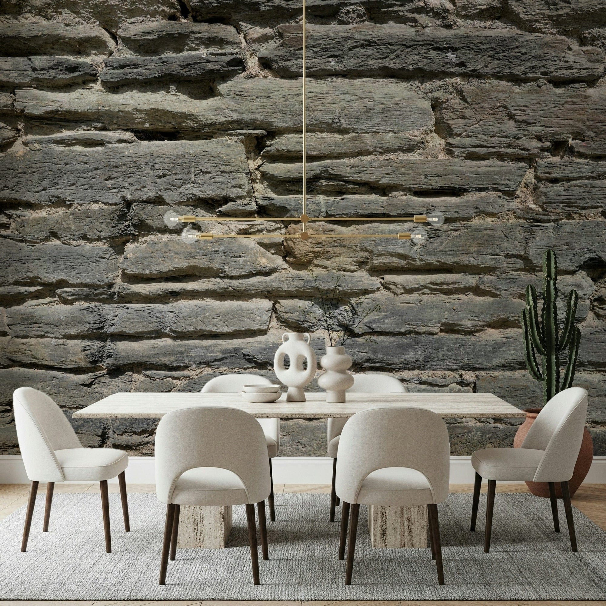 Grey Stone Layers wallpaper mural behind a cream dining table and chairs with a gold pendant in a dining room