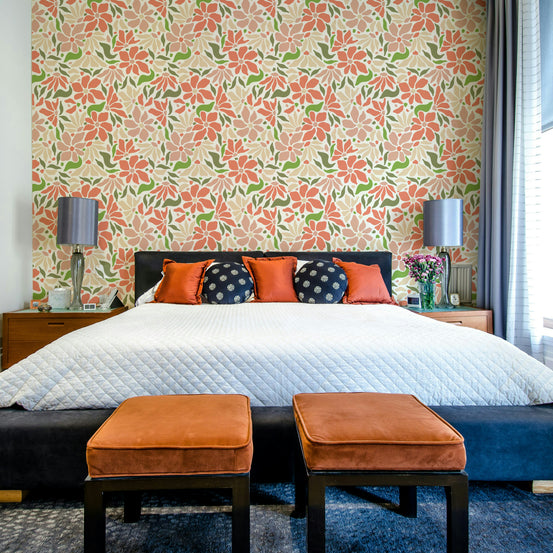 Groovy Flowers Coral Green wallpaper mural behind a black headboard bed with orange and navy pillows