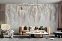 Grunge Gleam wallpaper mural in soft neutral leaves above a camel tan sofa and gold accent chair in a living room