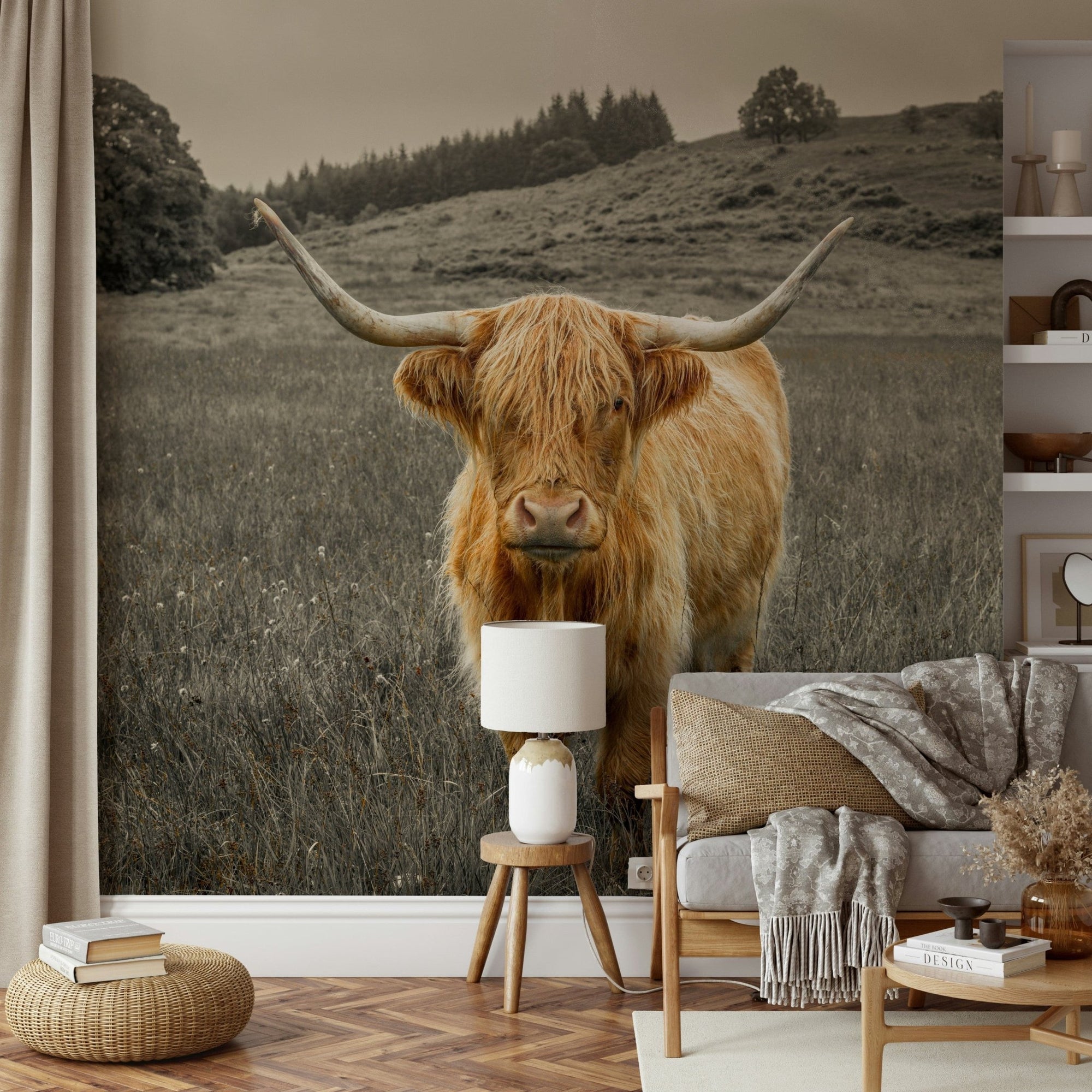Guardians of the Highlands wallpaper mural of a Highland cow in a meadow behind a grey sofa in a living room