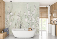 Hanging Flower on Green wallpaper mural of soft pink blossoms on sage green behind a freestanding tub in a bathroom