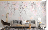 Hanging pink flowers wallpaper mural in pink and grey behind a beige sofa and gold table in a living room