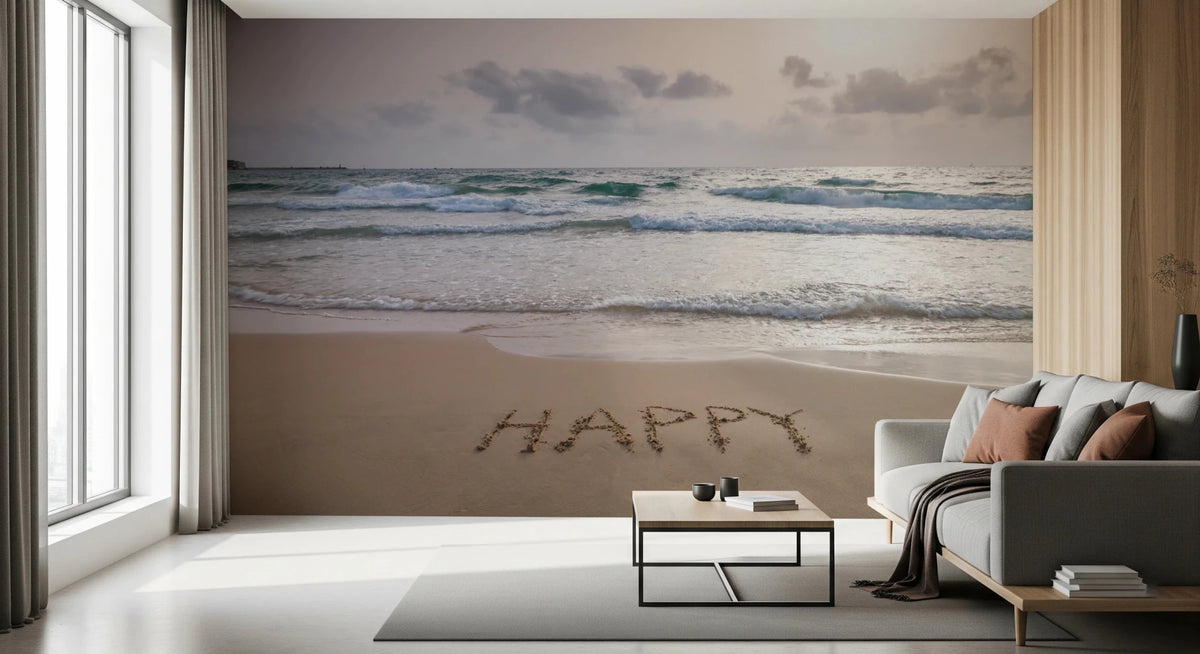 Happy Beach Vibes wallpaper mural of HAPPY written in sand by turquoise waves behind a grey sofa in a living room