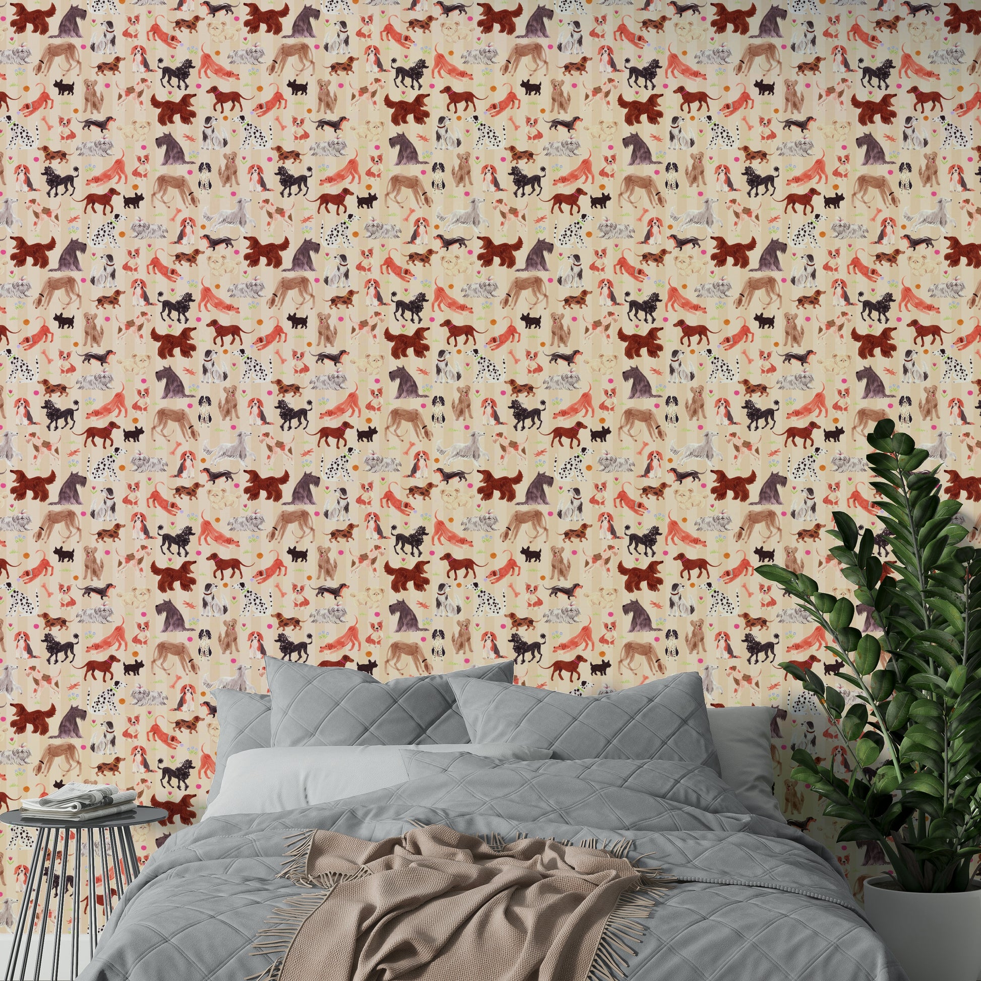 Happy Hounds Dog Doodles wallpaper of playful dogs behind a bed with grey bedding and a leafy green plant
