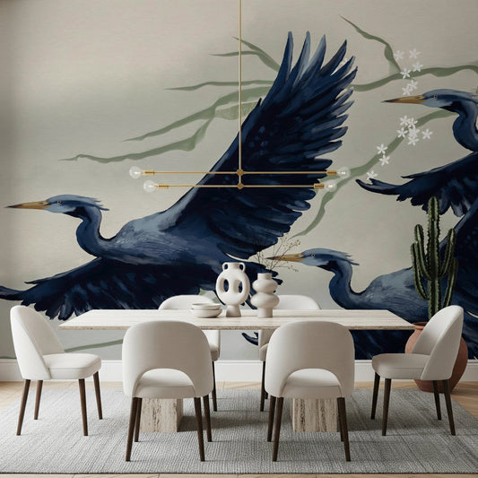 Heron Flight wallpaper mural of navy herons in flight behind a travertine table and cream chairs in a dining room