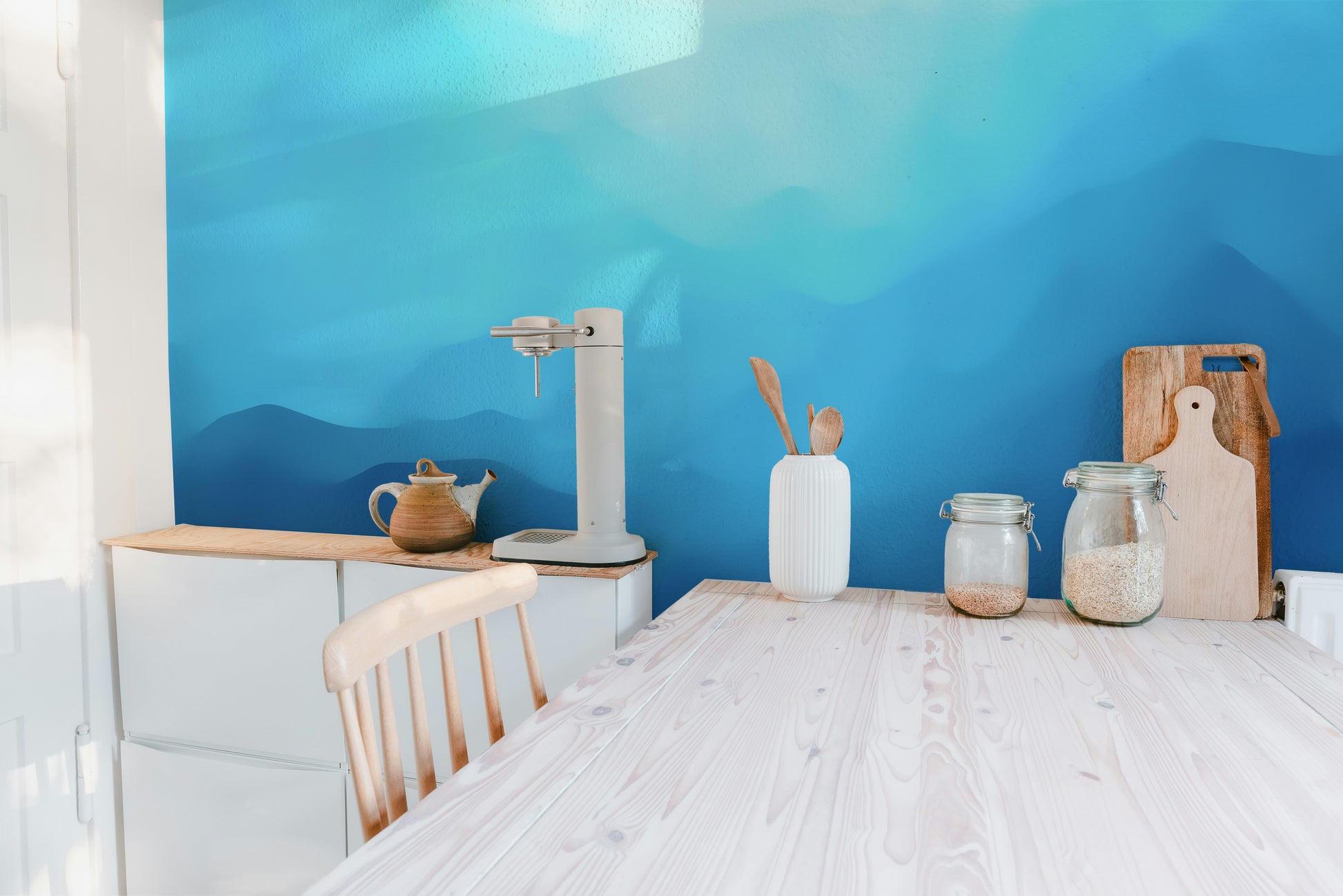 Indigo landscape wallpaper mural as a feature wall in a home office workspace in blue tones
