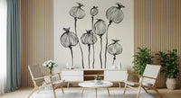 Ink Poppy Pods wallpaper mural with black seed pods behind a white credenza and woven lounge chairs