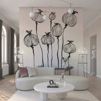 Ink Poppy Pods wallpaper mural of black seed pods behind a cream curved sofa with two globe floor lamps