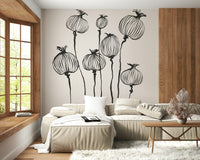 Ink Poppy Pods wallpaper mural with black ink pods above a beige leather sectional by a wood window seat