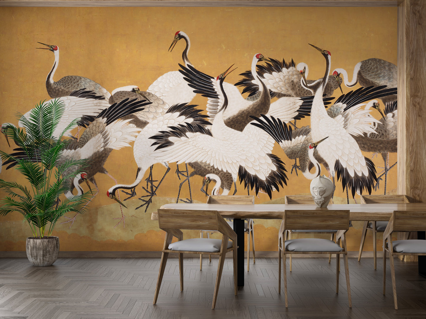 Japanese Flock Cranes wallpaper in gold behind a wooden dining table and potted palm in a dining room