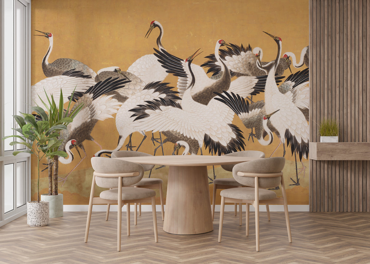 Japanese Flock Cranes wallpaper in gold and white behind a round wooden dining table in a dining area