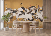 Japanese Flock Cranes wallpaper in gold and white behind a round wooden dining table in a dining area