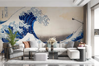 Katsushika Hokusai's The Great Wave off Kanagawa wallpaper mural of the blue wave behind a white sectional sofa and houndstooth ottoman