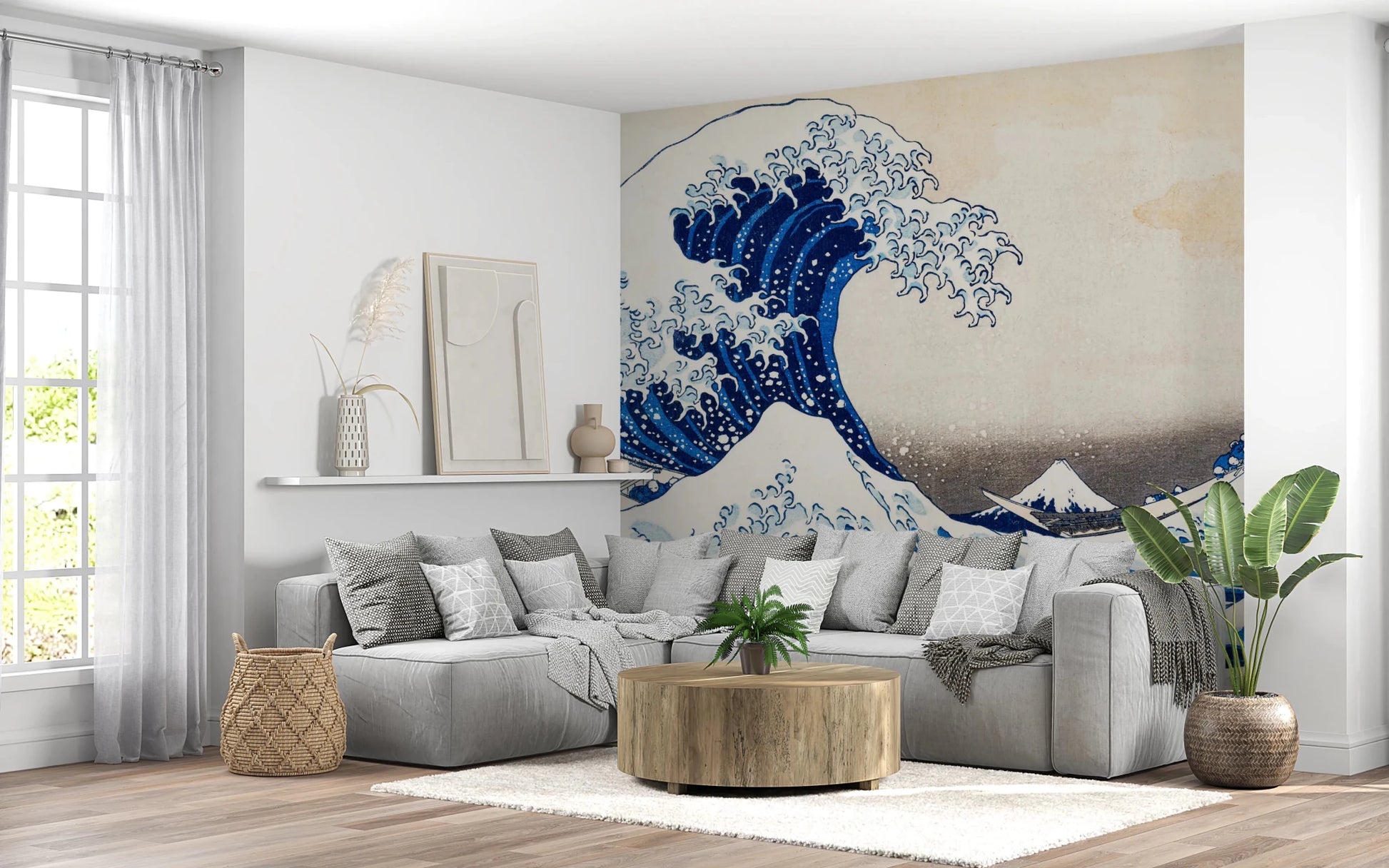 Katsushika Hokusai's The Great Wave off Kanagawa wallpaper mural with the blue wave behind a grey sectional sofa and round wooden table