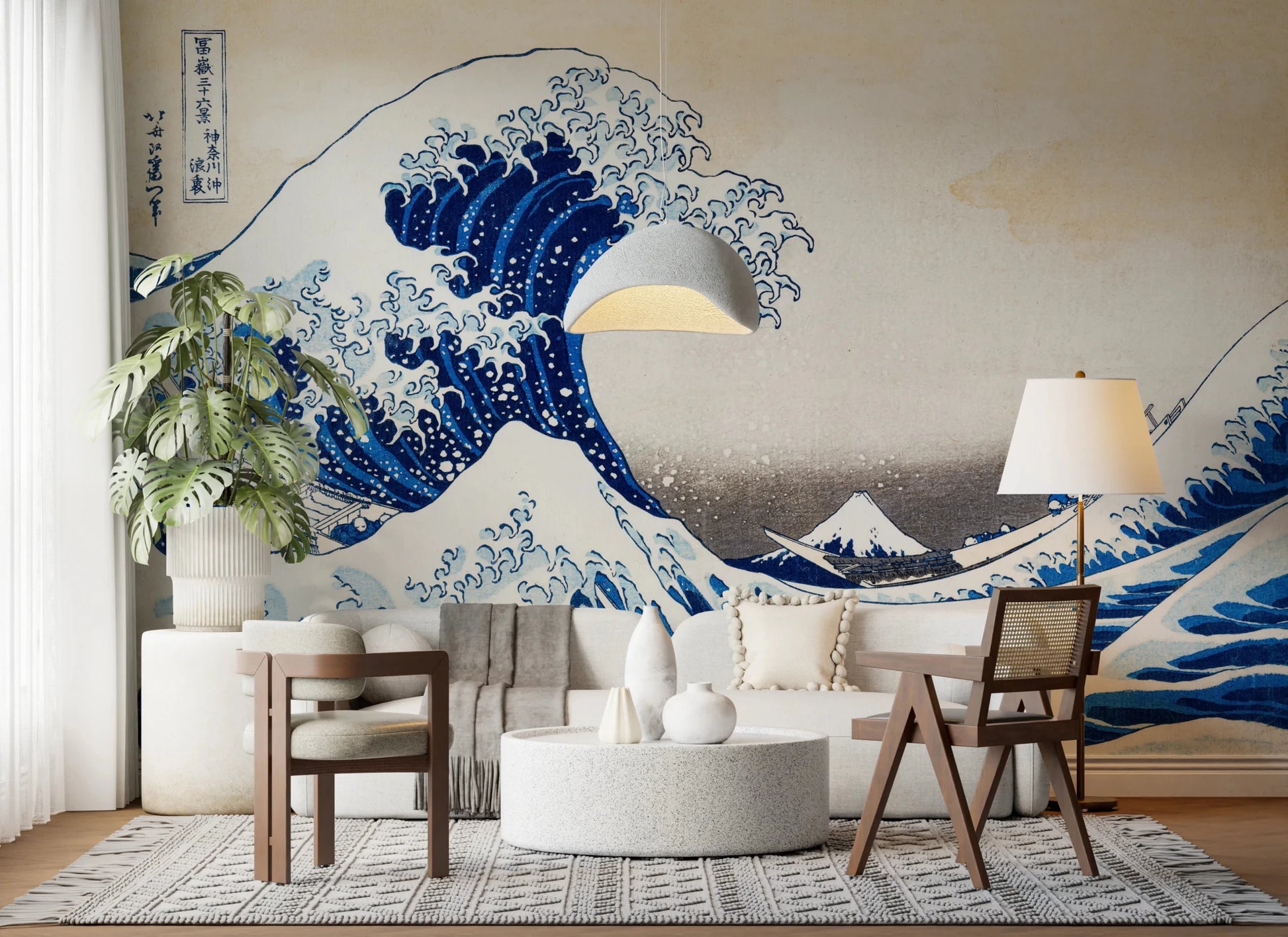Katsushika Hokusai's The Great Wave off Kanagawa wallpaper mural of the blue wave behind a white sofa, cane chair and terrazzo table