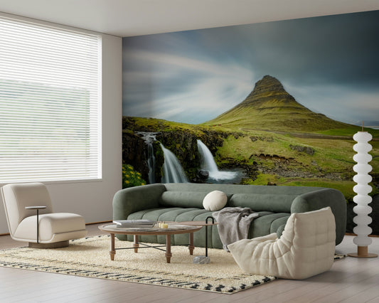Kirkjufell Mountain Serenity wallpaper mural of green peak and falls behind a sage green sofa in a bright living room