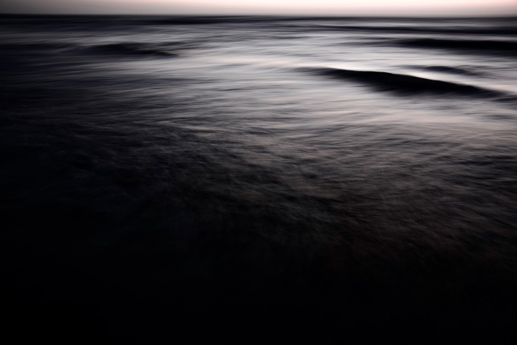 A graceful subtle gradient wall mural in cool, dark tones.

