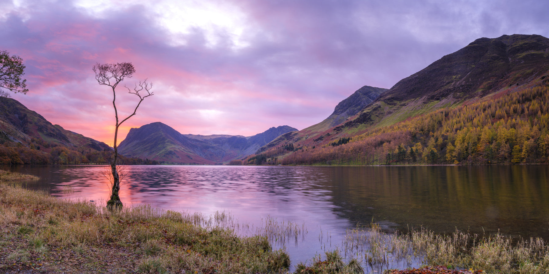 A beautiful serene lake wallpaper mural with mountains at sunset.

