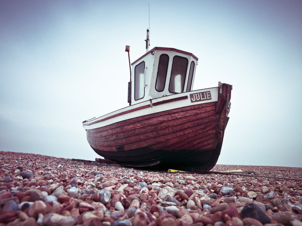 Boat Resting on Pebbled Strand Wall Mural in your room