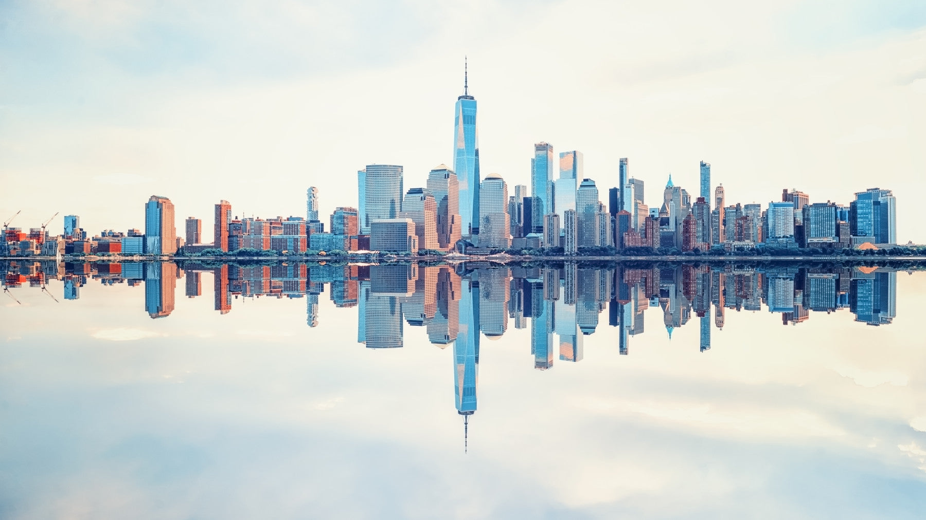 Mirrored Metropolis wallpaper mural of the mirrored Manhattan skyline behind a wood dining table and grey chairs