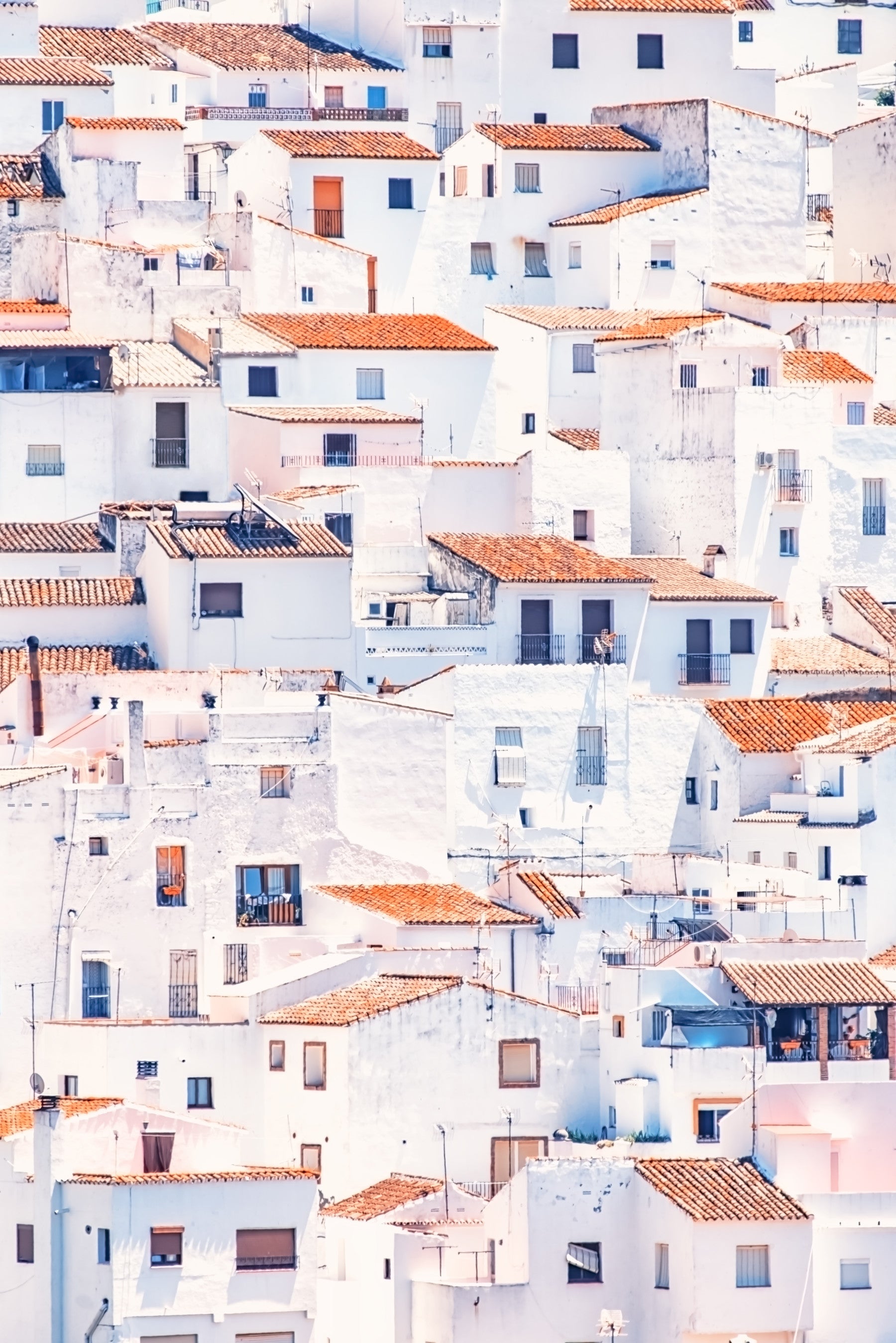 Spanish Townscape mural of whitewashed houses and terracotta roofs behind a beige sofa and armchair