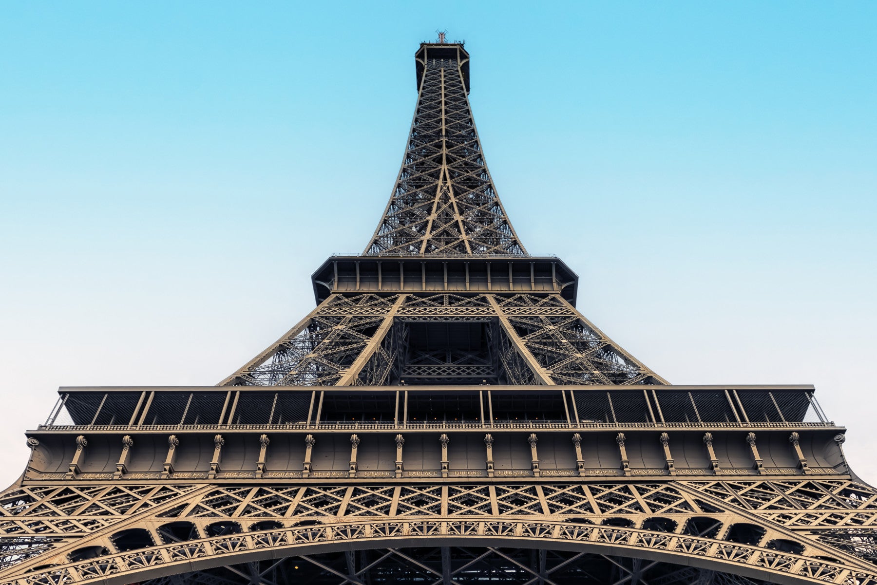 Eiffel's Azure Ascent wallpaper mural of the Eiffel Tower against a turquoise sky above a beige tufted sofa