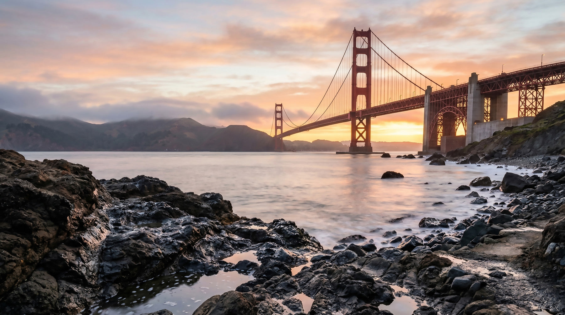 Golden Gate Bridge wall mural spanning the living room from corner to corner in sunset tones