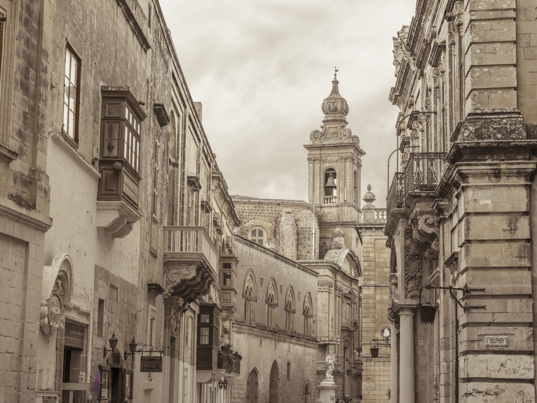 Sepia Mdina street and tower across a living room wall mura