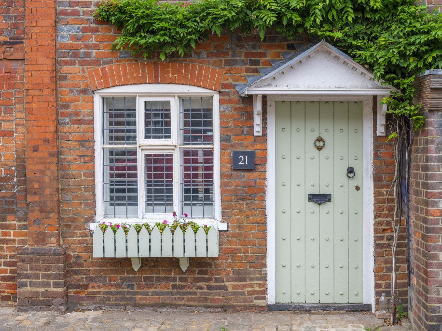English cottage wall mural with blooming flowers and stone facade
