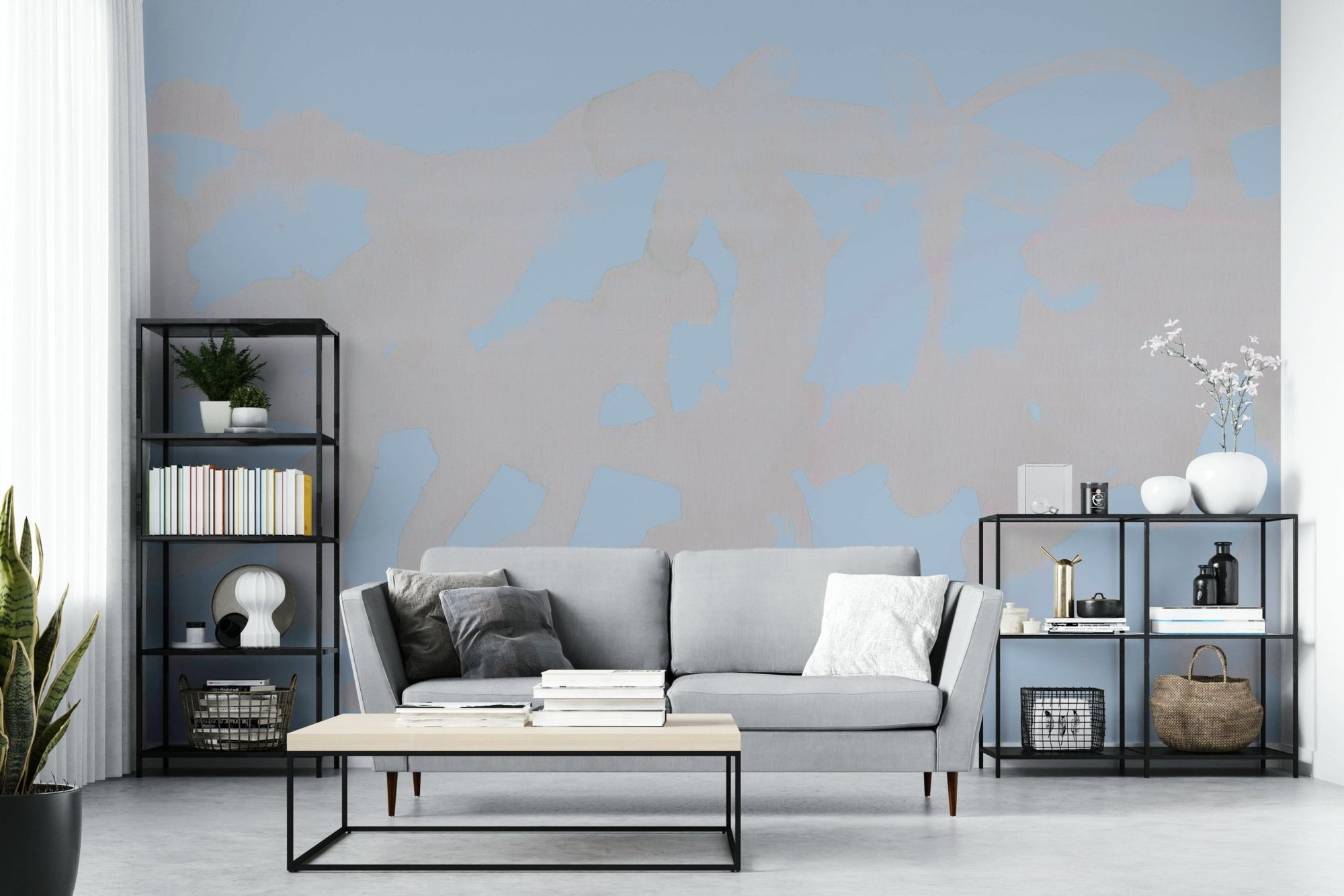 Lightscape Wash wallpaper mural with soft blue and beige abstract wash behind a grey sofa in a bright living room