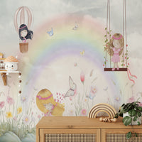 Little Girls Adventures wall mural with a watercolor rainbow above a wood sideboard with a wooden rainbow toy