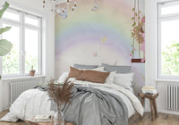 Little Girls Adventures wall mural with a pastel rainbow behind a gray bed and rust pillows in a bright bedroom
