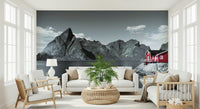 Scenic fjord mural showcasing dramatic rocky peaks reflected in still Nordic waters beside a red house.