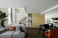 Stylized floral and leaf patterns in yellow and sage green on a wall.

