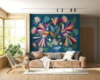 Love Birds mural in rainbow colors on teal behind a beige sofa and wooden lounge chair in a living room