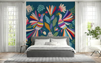 Love Birds mural of bright folk birds on blue forming a headboard over a gray bed in a bedroom