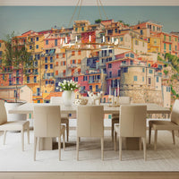 Manarola Vista wall mural of Cinque Terre houses behind a white dining table and gold ring chandelier