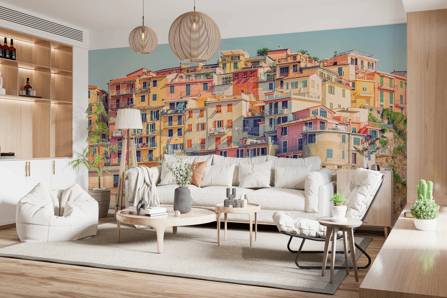 Manarola Vista wall mural of stacked Italian houses behind a white sofa and woven pendants in a living room